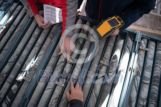 geological gold core samples with team of mining workers measuring drilled rock top view geological gold core samples with team of mining workers measuring drilled rock top view