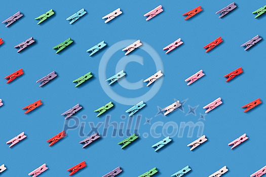 Horizontal laundry pattern from colorful clothes pins on a blue background. Top view. Horizontal laundry pattern from colorful clothes pins on a blue background. Top view.