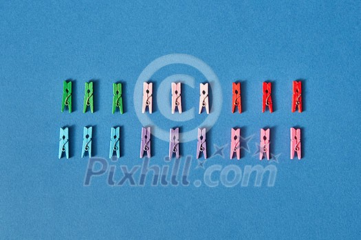 Colorful clothespegs made of two rows on a blue background with soft shadows and copy space. Flat lay. Colorful clothespegs made of two rows on a blue background with soft shadows and copy space. Flat lay.