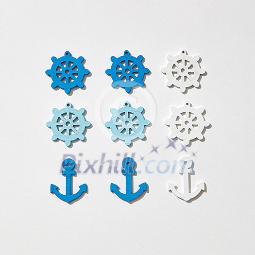 Ship anchors and wheel different colors pattern on a light grey background with hard shadows, copy space. Flat lay Ship anchors and wheel different colors pattern on a light grey background with hard shadows, copy space. Flat lay