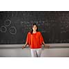 Pretty, young college student/young teacher writing on the chalkboard/blackboard during a math class