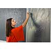 Pretty, young college student/young teacher writing on the chalkboard/blackboard during a math class