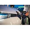 Young woman charging an electric vehicle. Car sharing concept.