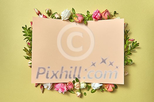 Fresh natural organic flower frame with paper congratulation card on a light olive background with copy space. Valentine's greeting card. Fresh natural organic flower frame with paper congratulation card on a light olive background with copy space. Valentine's greeting card.