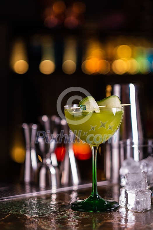 Alcoholic cocktail of green color on a bar counter. Cucumber cocktail. Alcoholic cocktail of green color on a bar counter. Cucumber cocktail.