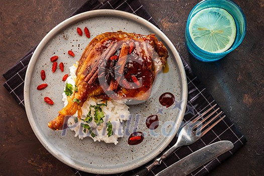 Duck leg confit with rice and goji berries. Traditional french cuisine. View from above. Duck leg confit with rice and goji berries. Traditional french cuisine. View from above.