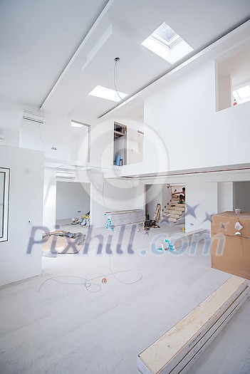 Interior of unfinished stylish modern open space two level apartment with white walls soon ready to move in Interior of unfinished stylish modern open space two level apartment with white walls soon ready to move in