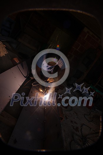 welder with protective mask welding steel structures and bright sparks in construction industry welder with protective mask welding steel structures and bright sparks in construction industry