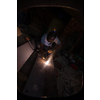 welder with protective mask welding steel structures and bright sparks in construction industry