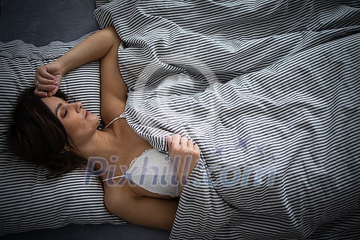 Pretty, young woman in her bed, fast asleep. Importance of sleep concept Pretty, young woman in her bed, fast asleep. Importance of sleep concept
