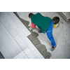 skilled worker installing the ceramic wood effect tiles on the floor Worker making laminate flooring on the construction site of the new apartment