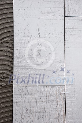Ceramic wood effect tiles and tools for tiler on the floor unfinished laying floor tiles Floor tiles installation Ceramic wood effect tiles and tools for tiler on the floor unfinished laying floor tiles Floor tiles installation
