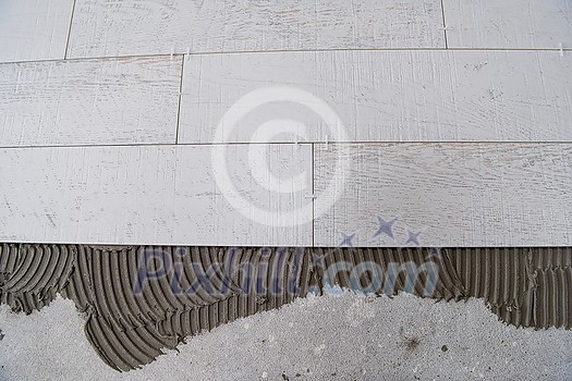 Ceramic wood effect tiles and tools for tiler on the floor unfinished laying floor tiles Floor tiles installation Ceramic wood effect tiles and tools for tiler on the floor unfinished laying floor tiles Floor tiles installation