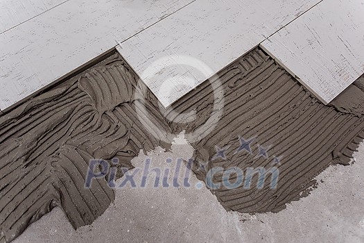 Ceramic wood effect tiles and tools for tiler on the floor unfinished laying floor tiles Floor tiles installation Ceramic wood effect tiles and tools for tiler on the floor unfinished laying floor tiles Floor tiles installation