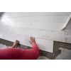 skilled worker installing the ceramic wood effect tiles on the floor Worker making laminate flooring on the construction site of the new apartment