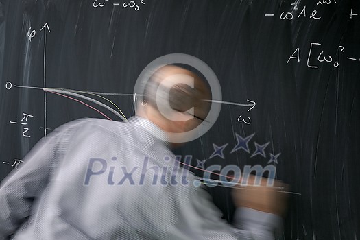 Math teacher drawing fuction graph on a blackboard during mathclass (motion blurred image) Math teacher drawing fuction graph on a blackboard during mathclass (motion blurred image)