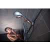 Pretty, young woman taking a long hot shower washing her hair in a modern design bathroom