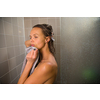 Pretty, young woman taking a long hot shower washing her hair in a modern design bathroom