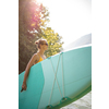 Pretty, young woman paddling on a paddle board on a lake, enjoying a lovely summer day