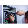 Closeup of electrician engineer working with electric cable wires of modern fuse switch box. Electrical equipment adjusting new voltage wiring