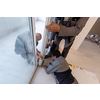 professional carpenters installing a balcony door in a new apartment with panoramic windows