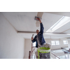 young professional construction worker using scaffold while plastering on gypsum ceiling inside the new big modern two levels apartment