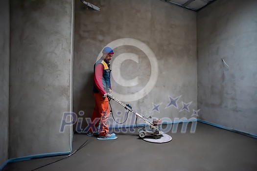 Laborer performing and polishing sand and cement screed floor on the construction site of a new two-level apartment. Sand and cement floor screed Laborer performing and polishing sand and cement screed floor on the construction site of a new two-level apartment. Sand and cement floor screed