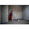 Laborer performing and polishing sand and cement screed floor on the construction site of a new two-level apartment. Sand and cement floor screed