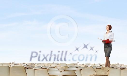 Pretty businesswoman walking on pile of old books Pretty businesswoman walking on pile of old books