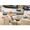 Pretty, young woman choosing the right furniture for her apartment in a modern home furnishings store (color toned image; shallow DOF)