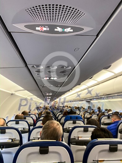 Cabin of a modern airplane filled with passangers to its full capacity during flight, after delayed departure (shallow DOF) Cabin of a modern airplane filled with passangers to its full capacity during flight, after delayed departure (shallow DOF)