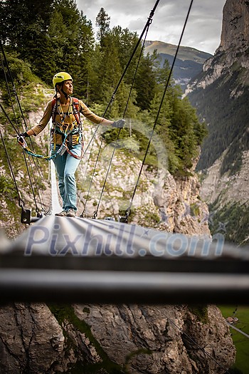 Pretty, female climber on a via ferrata - climbing on a rock in Swiss Alps Pretty, female climber on a via ferrata - climbing on a rock in Swiss Alps