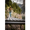 Pretty, female climber on a via ferrata - climbing on a rock in Swiss Alps