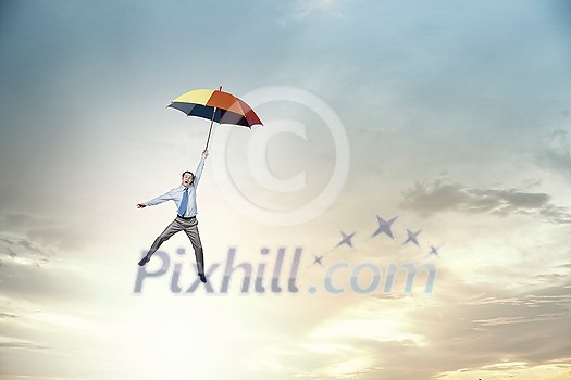 Young businessman flying high in sky on umbrella Young businessman flying high in sky on umbrella