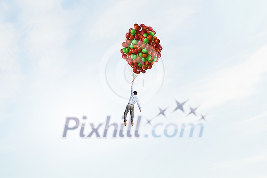Young successful businessman flies on bunch of colorful balloons Young successful businessman flies on bunch of colorful balloons