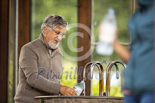 Handsome senior man drinking mineral water in a spa/health resort, enjoying its health benefits Handsome senior man drinking mineral water in a spa/health resort, enjoying its health benefits