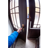 the man in the blue jacket opening door of a building to get out