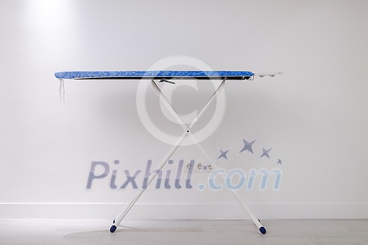 ironing board in front of white wall ironing board in front of white wall
