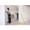 male workers carpenters installing interior glass door with a wooden frame at new luxury apartment