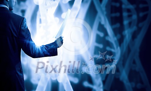 Businessman standing with paper in hand and virtual panel with dna spiral Businessman standing with paper in hand and virtual panel with dna spiral
