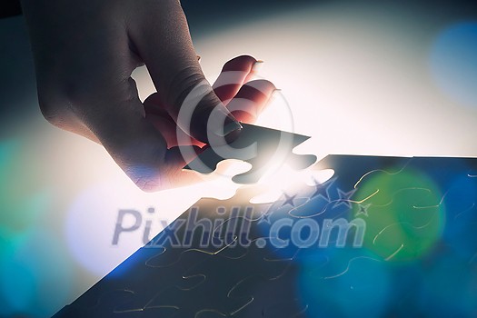 Hand connecting missing jigsaw glowing puzzle piece Hand connecting missing jigsaw glowing puzzle piece