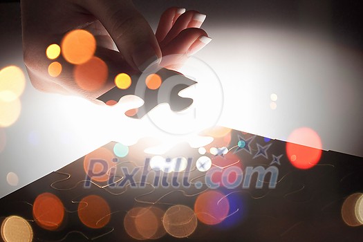 Hand connecting missing jigsaw glowing puzzle piece Hand connecting missing jigsaw glowing puzzle piece
