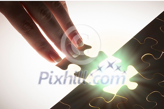 Hand connecting missing jigsaw glowing puzzle piece Hand connecting missing jigsaw glowing puzzle piece