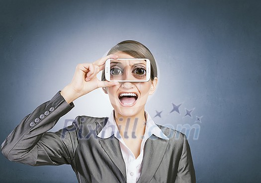 Beautiful young woman holding mobile phone against her eyes