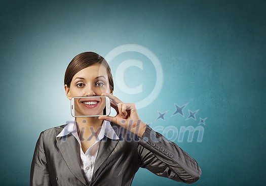 Beautiful young woman holding mobile phone against her mouth and smiling Beautiful young woman holding mobile phone against her mouth and smiling