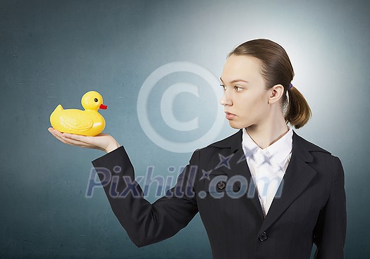 Young businesswoman holding yellow rubber duck toy in palm Young businesswoman holding yellow rubber duck toy in palm