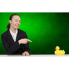 Young businesswoman pointing with finger at yellow rubber duck toy on table