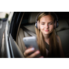 Cute teenage girl in a car, enjoying the ride - looking for the best possible data coverage for her phone
