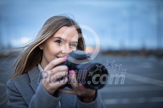 Pretty, young woman taking photos with her professional dslr camera Pretty, young woman taking photos with her professional dslr camera
