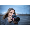 Pretty, young woman taking photos with her professional dslr camera